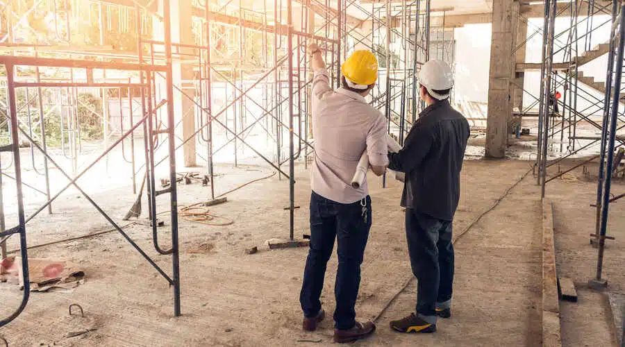 The principal contractor discusses a project with the architect on site.