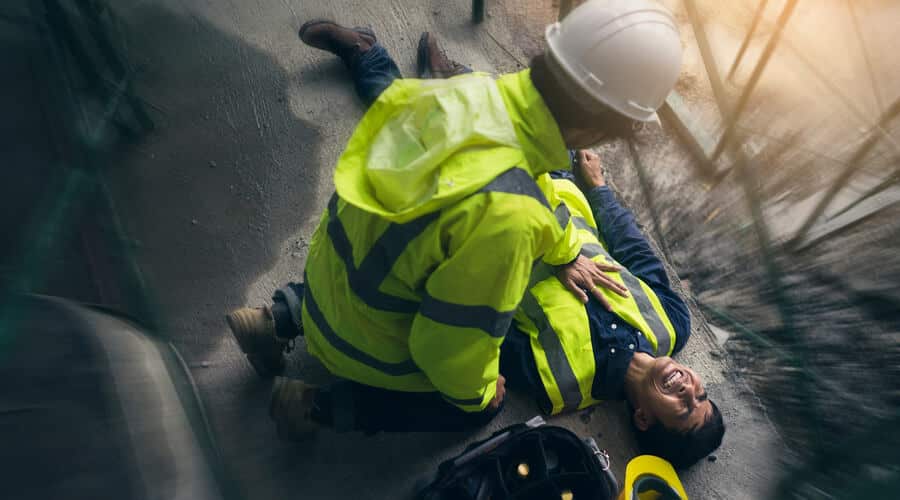 A WHS incident is an unplanned event at work that can cause harm. The image shows an event like this on a construction site - a worker is hurt.
