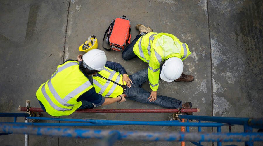 Construction worker lays hurt on the ground indicating a notifiable incident