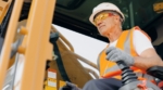 Image of a construction worker operating a forklift. Before starting he consulted a Safe Operating Procedure.